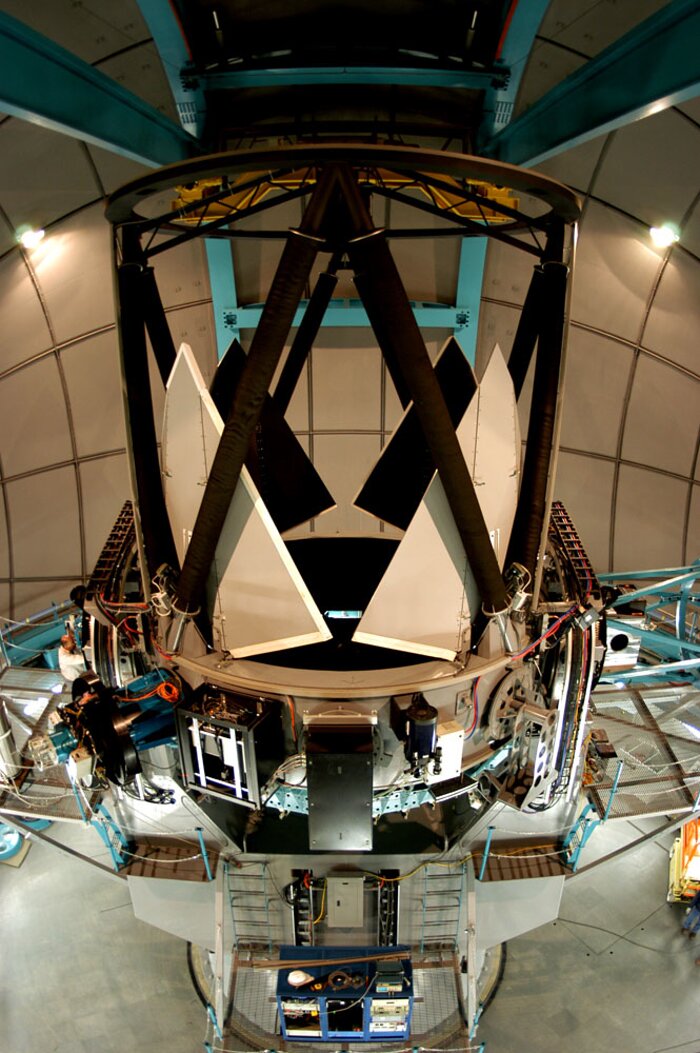 Side view of the SOAR telescope, showing the Serrurier structure that supports the secondary mirror, and the primary mirror protective petals in the open position.