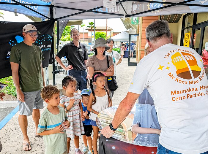 Familia visitan el stand de NOIRLab en AstroDay Kona 2024