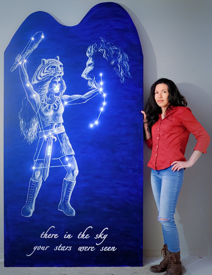 Stéphanie Juneau next to her artwork of Orion as 